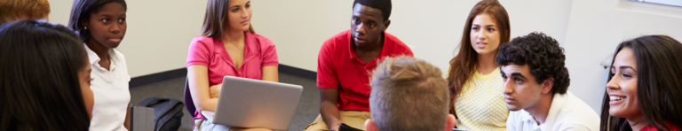 Diverse group of high school students sit in a circle in chairs discussing ideas.