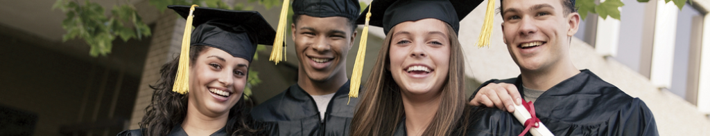 Group of four diverse, smiling high school graduates wearing caps and gowns.