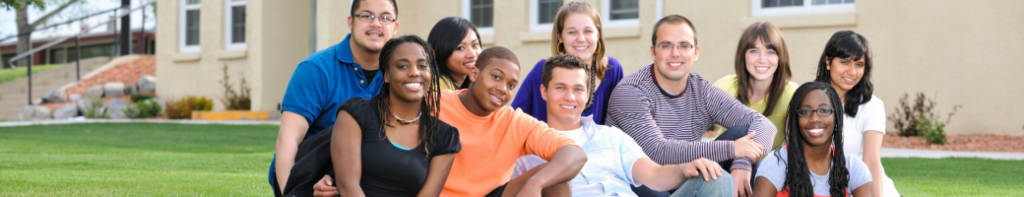 Diverse group of high school students sitting and smiling together outside a school building.
