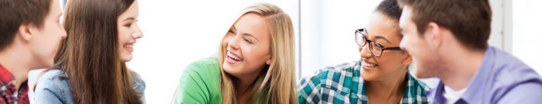 Diverse group of high school students smiling with each other.