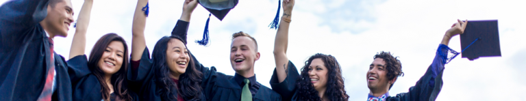 Diverse group of high school graduates celebrating in their caps and gowns.