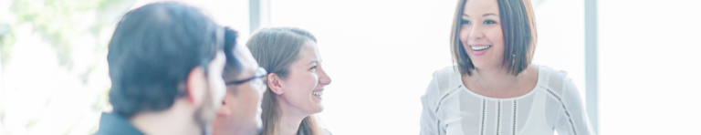 Smiling professional woman leading a group of three other professionals.